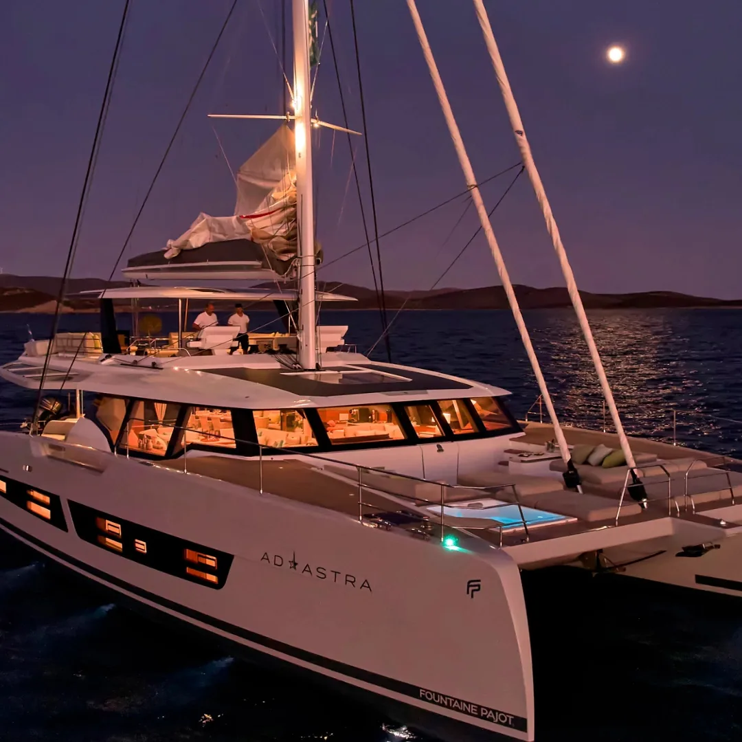 Catamaran at anchor under moonlight